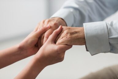 Mains qui tiennent les mains d'une personne âgée