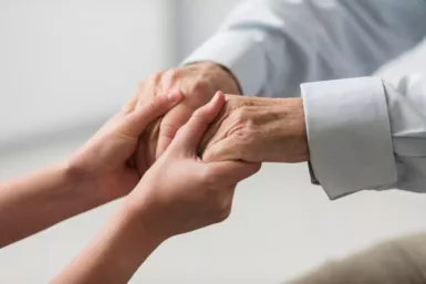 Mains qui tiennent les mains d'une personne âgée
