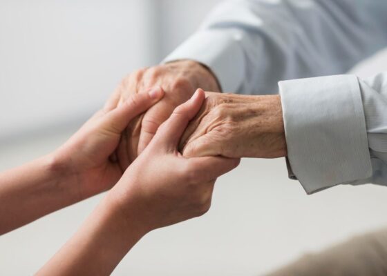 Mains qui tiennent les mains d'une personne âgée
