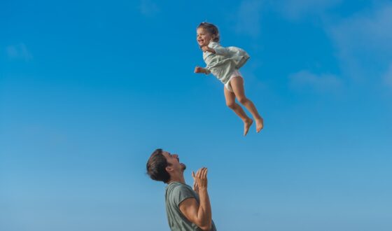 a man and a little girl flying through the air